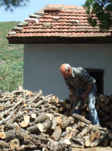 Griechischer Rentner beim hacken von Feuerholz